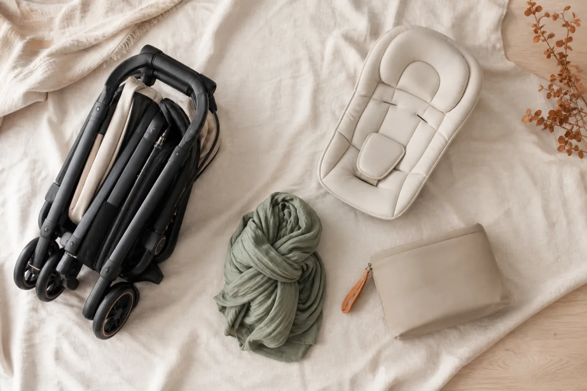 Illustrative flat lay of unbranded stroller and baby travel essentials